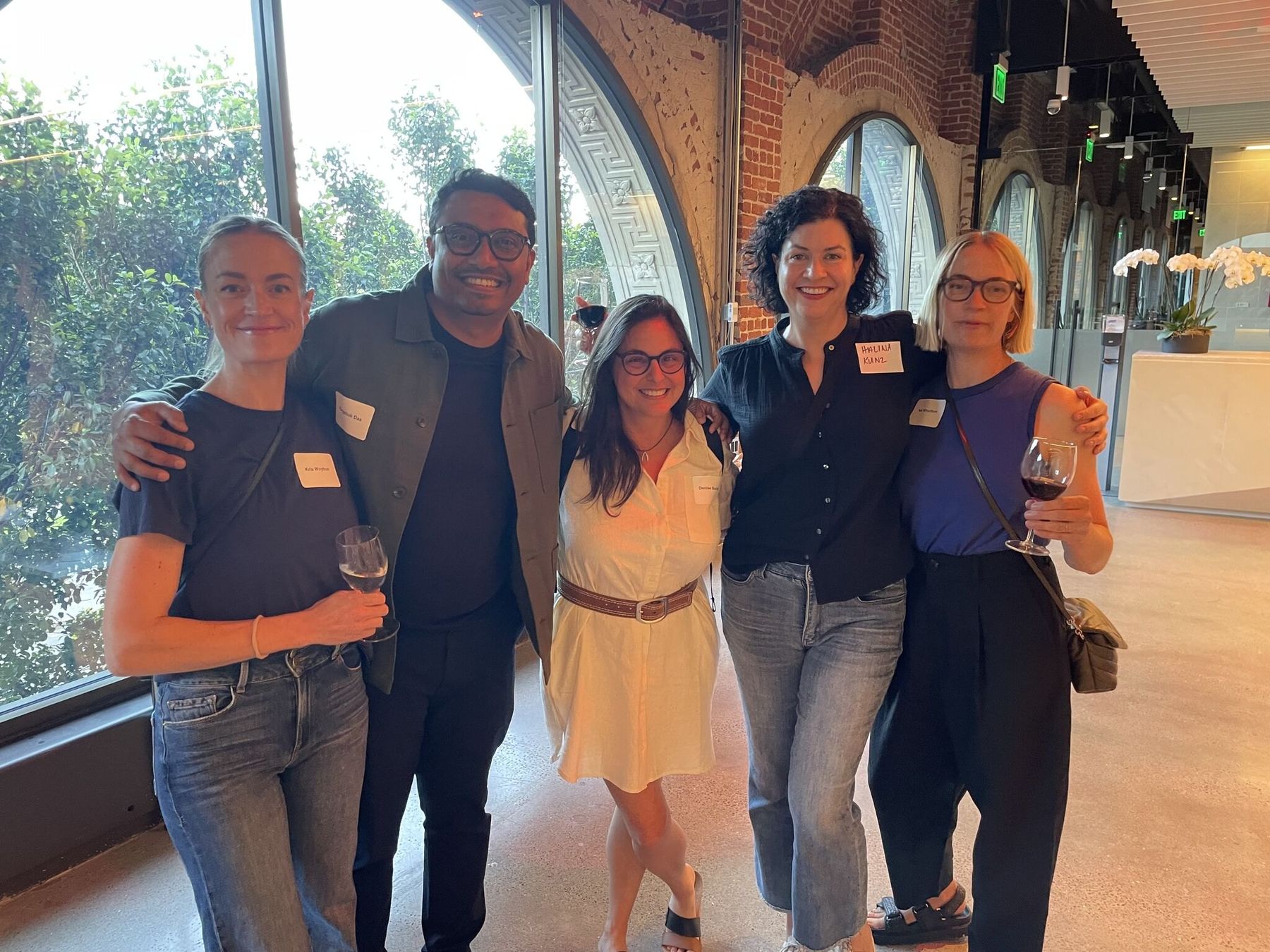 A group of members together by arched windows at a Design Leaders gathering