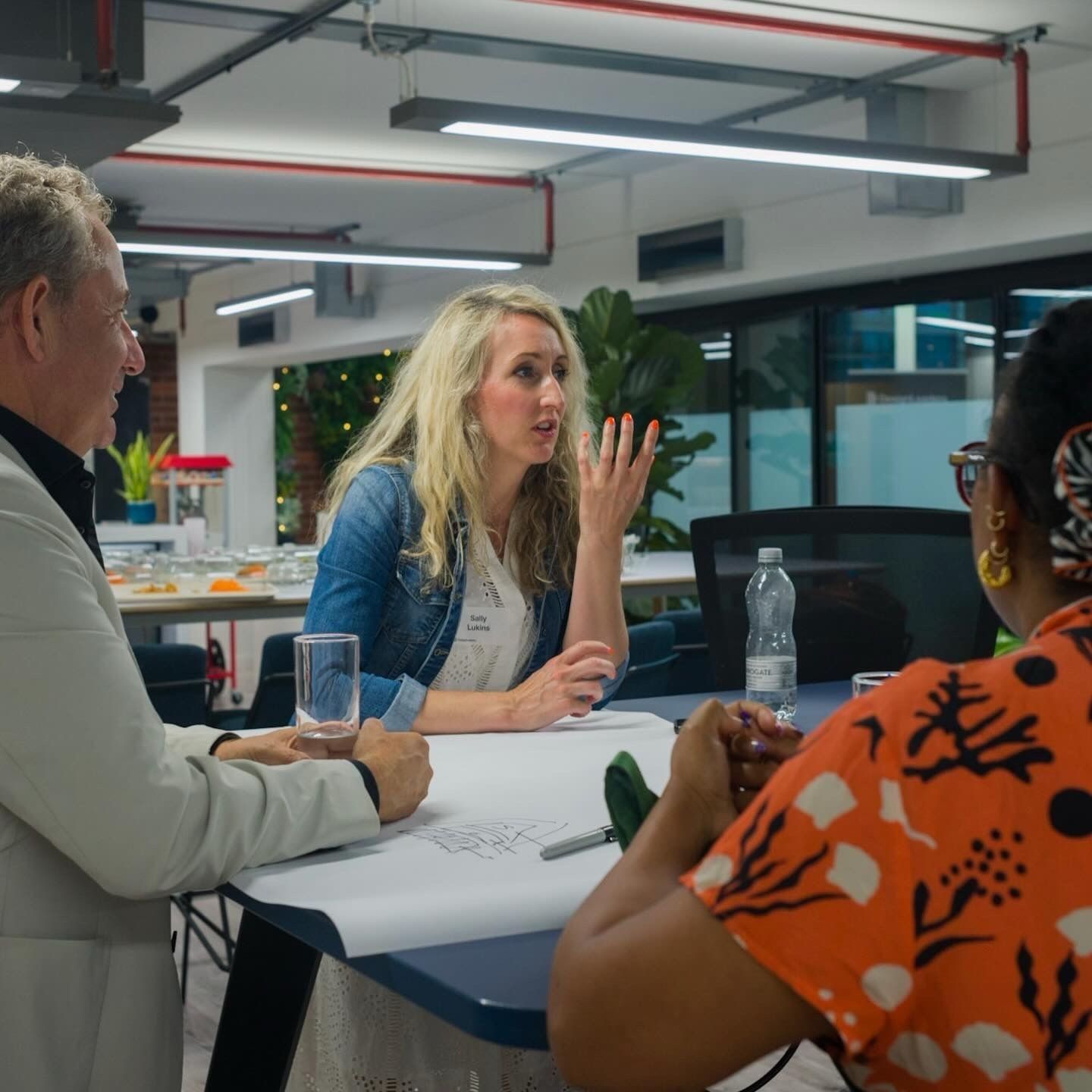 A member speaking during a table discussion at a Design Leaders gathering