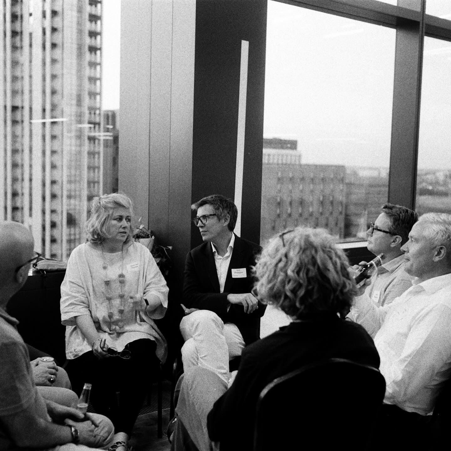 A small group of design leaders in conversation by a window